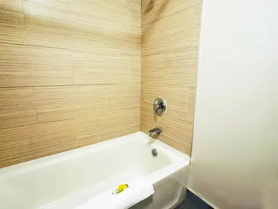 a bathroom with a white bath tub and wooden walls at Baymont Inn and Suites by Wyndham Columbus / Near OSU in Columbus