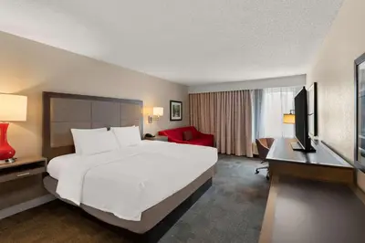 a hotel room with a large white bed and a desk at Hampton Inn Lancaster in Lancaster
