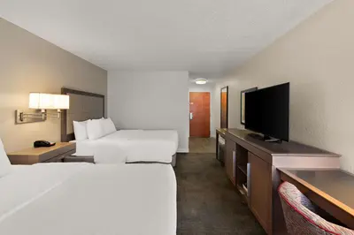 a hotel room with two beds and a flat screen tv at Hampton Inn Lancaster in Lancaster