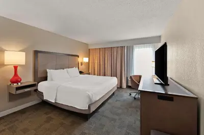 a hotel room with a bed and a flat screen tv at Hampton Inn Lancaster in Lancaster