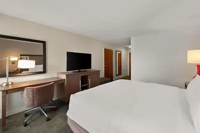 a hotel room with a bed and a desk with a computer at Hampton Inn Lancaster in Lancaster