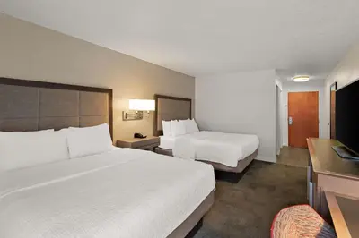 a hotel room with two beds and a desk at Hampton Inn Lancaster in Lancaster