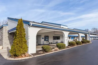 a large white building with an archway on a street at Days Inn by Wyndham Kent - Akron in Kent