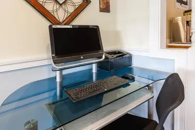 a glass desk with a computer on top of it at Days Inn by Wyndham Kent - Akron in Kent