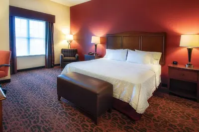 a hotel room with a large bed and a chair at Hampton Inn Oxford/Miami University Area in Oxford