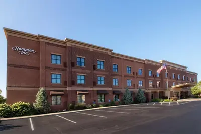 a large red brick building with an american flag at Hampton Inn Oxford/Miami University Area in Oxford