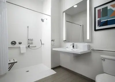 a bathroom with a toilet and a sink and a mirror at Holiday Inn - Cincinnati - Liberty Way by IHG in West Chester