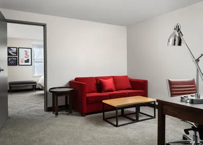 a living room with a red couch and a table at Holiday Inn - Cincinnati - Liberty Way by IHG in West Chester