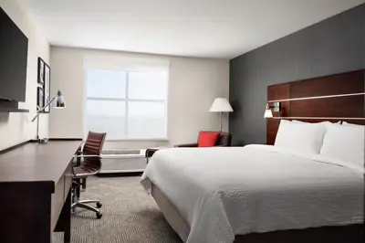 a hotel room with a large bed and a desk at Holiday Inn - Cincinnati - Liberty Way by IHG in West Chester
