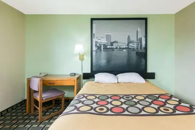 a room with a bed and a desk and a window at Super 8 by Wyndham Twinsburg/Cleveland Area in Twinsburg