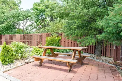 a wooden picnic table sitting on a brick patio at Super 8 by Wyndham Twinsburg/Cleveland Area in Twinsburg