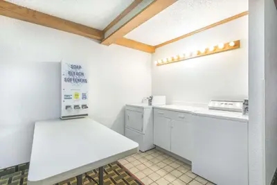 a small kitchen with a counter and a washer and dryer at Super 8 by Wyndham Twinsburg/Cleveland Area in Twinsburg