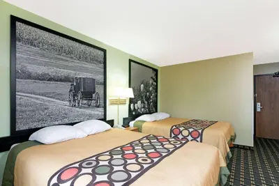 a hotel room with two beds and a picture of a car at Super 8 by Wyndham Twinsburg/Cleveland Area in Twinsburg