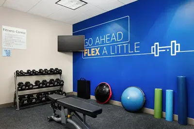 a gym with a blue wall with a sign saying go ahead play aittle at Holiday Inn Express and Suites Wheeling by IHG in Triadelphia