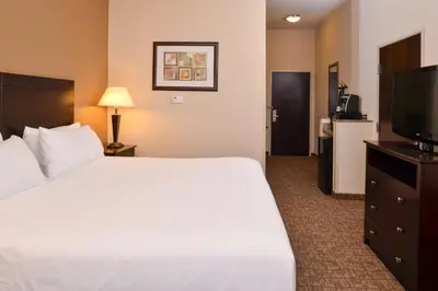 a hotel room with a bed and a flat screen tv at Holiday Inn Express and Suites Wheeling by IHG in Triadelphia