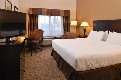 a hotel room with a bed and a flat screen tv at Holiday Inn Express and Suites Wheeling by IHG in Triadelphia