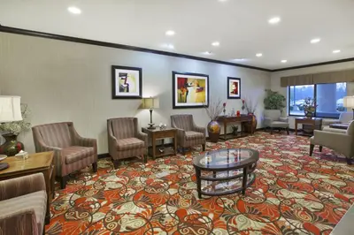 a lobby with a waiting room with chairs and a table at Holiday Inn Express and Suites Wheeling by IHG in Triadelphia