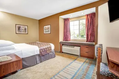 a hotel room with a bed and a window at Microtel Inn & Suites by Wyndham Mason in Mason