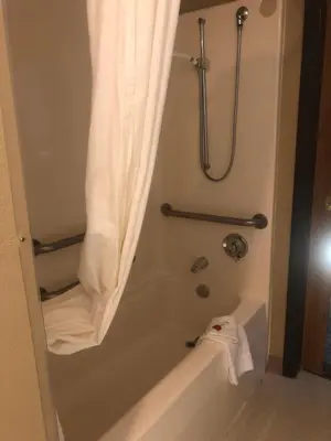 a bathroom with a bath tub with a shower curtain at Microtel Inn & Suites by Wyndham Mason in Mason