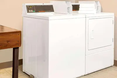 a white washer and dryer sitting next to a table at Microtel Inn & Suites by Wyndham Mason in Mason