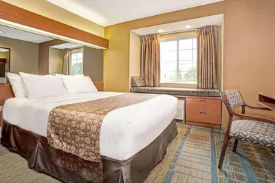 a hotel room with a bed and a desk and a window at Microtel Inn & Suites by Wyndham Mason in Mason