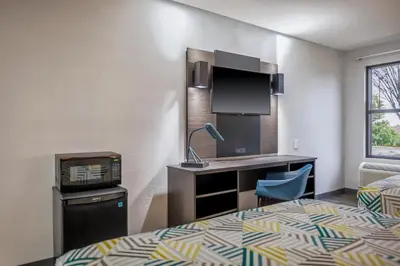 a hotel room with a bed and a desk and a sink at Motel 6 - Franklin, OH in Franklin