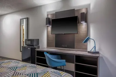 a hotel room with a bed and a desk with a tv at Motel 6 - Franklin, OH in Franklin
