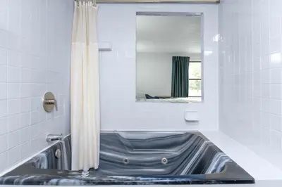 a bathroom with a tub with a shower curtain at Motel 6 - Franklin, OH in Franklin