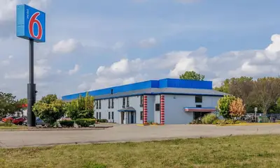 a building with a blue roof and a parking lot at Motel 6 - Franklin, OH in Franklin