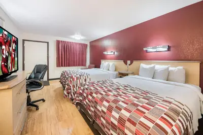 a hotel room with two beds and a flat screen tv at Red Roof Inn Columbus - Grove City in Grove City