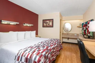 a hotel room with a bed and a desk at Red Roof Inn Columbus - Grove City in Grove City