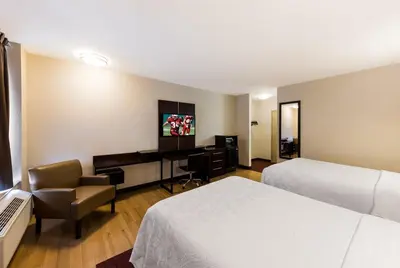a hotel room with two beds and a desk at Red Roof Inn PLUS+ Columbus Downtown - Convention Center in Columbus