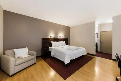 a bedroom with a bed and a chair at Red Roof Inn PLUS+ Columbus Downtown - Convention Center in Columbus