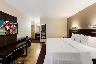 a hotel room with a large bed and a flat screen tv at Red Roof Inn PLUS+ Columbus Downtown - Convention Center in Columbus
