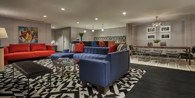 a living room with couches and a dining room at Graduate by Hilton Cincinnati in Cincinnati