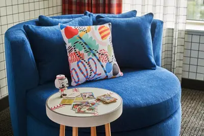a blue couch with a blue pillow and a table at Graduate by Hilton Cincinnati in Cincinnati