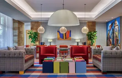 a lobby with couches and chairs and a table at Graduate by Hilton Cincinnati in Cincinnati