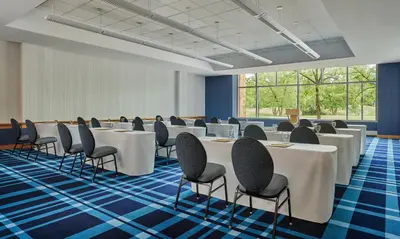 a conference room with white tables and chairs at Graduate by Hilton Cincinnati in Cincinnati