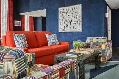 a living room with an orange couch and chairs at Graduate by Hilton Cincinnati in Cincinnati