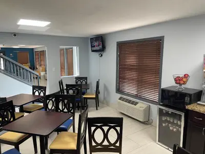 a dining room with tables and chairs and a tv at Days Inn by Wyndham Muncie -Ball State University in Muncie
