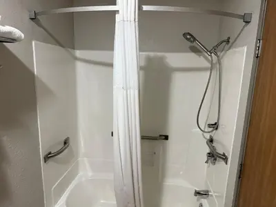 a shower in a bathroom with a shower curtain at Days Inn by Wyndham Muncie -Ball State University in Muncie