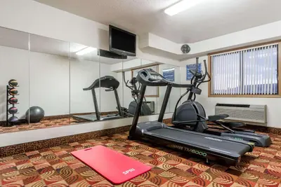a gym with two exercise bikes and a treadmill at Days Inn by Wyndham Muncie -Ball State University in Muncie