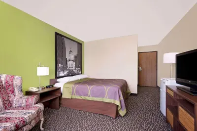 a hotel room with a bed and a couch at Super 8 by Wyndham Muncie/Ball St. College Area in Muncie