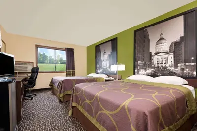 a hotel room with two beds and a television at Super 8 by Wyndham Muncie/Ball St. College Area in Muncie