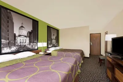 a hotel room with two beds and a flat screen tv at Super 8 by Wyndham Muncie/Ball St. College Area in Muncie