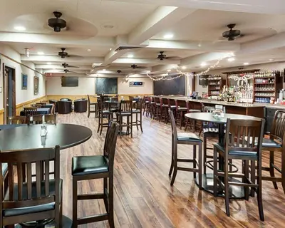 a restaurant with tables and chairs and a bar at Quality Inn Montpelier in Montpelier