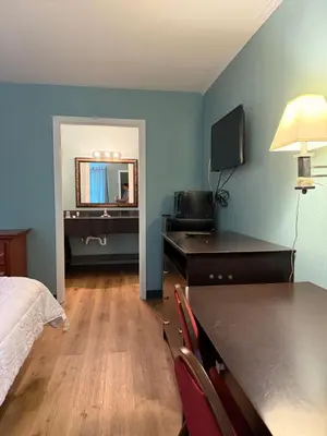a hotel room with a bed and a desk with a television at Country Club Inn & Suites in Fostoria