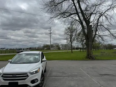 a white car parked in a parking lot at Country Club Inn & Suites in Fostoria