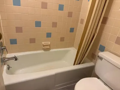 a bathroom with a white tub and a toilet at Country Club Inn & Suites in Fostoria