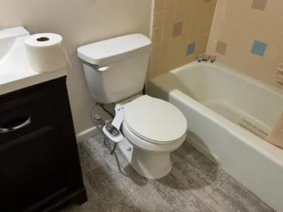 a bathroom with a toilet and a sink and a tub at Country Club Inn & Suites in Fostoria